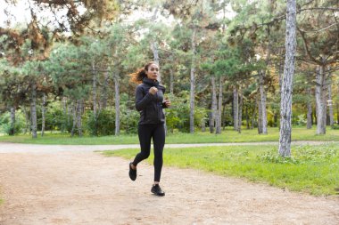 Yeşil parkı ile çalışırken çalışma dışarı sporcumuz 20'li yaşlarda giyen siyah eşofman görüntüsünü