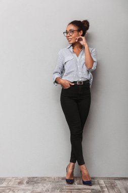 Gri arka plan üzerinde duran bir güzel genç Afrika iş kadın tam uzunlukta