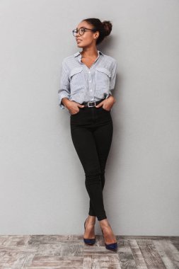 Gri arka plan üzerinde duran bir güzel genç Afrika iş kadın tam uzunlukta