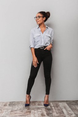 Gri arka plan üzerinde duran bir güzel genç Afrika iş kadın tam uzunlukta