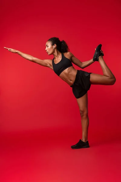 Портрет Гимнастки Африканской Женщины Черной Спортивной Одежде Выполняющей Упражнения Красном — стоковое фото