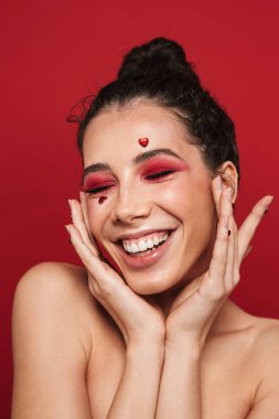 Çekici bir genç üstsüz kadın izole kırmızı arka plan üzerinde duran, poz makyaj Güzellik Portresi