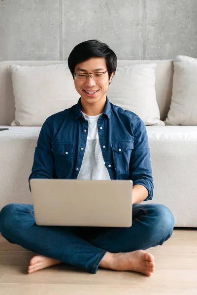 Feliz Hombre Asiático Sentado Sofá Casa Utilizando Ordenador Portátil —  Fotos de Stock