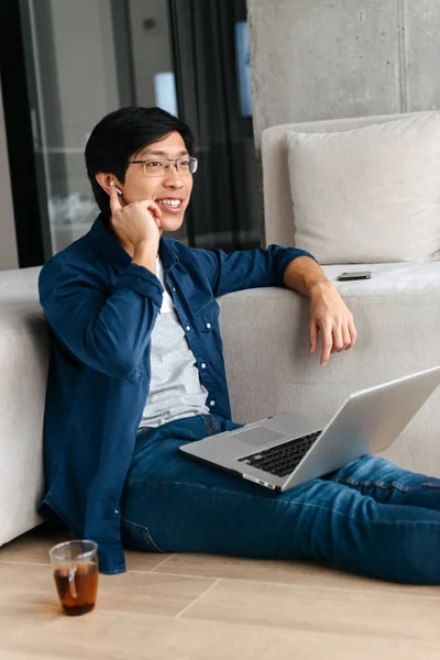 Glücklicher Asiatischer Mann Der Hause Auf Einer Couch Sitzt Laptop — Stockfoto