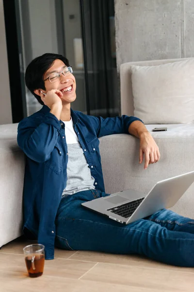 Feliz Hombre Asiático Sentado Sofá Casa Utilizando Ordenador Portátil Hablando — Foto de Stock