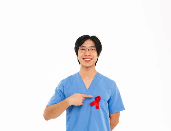 Uśmiechnięty Człowiek Asian Lekarza Sobie Mundur Czerwoną Wstążką Stojąc Białym — Zdjęcie stockowe