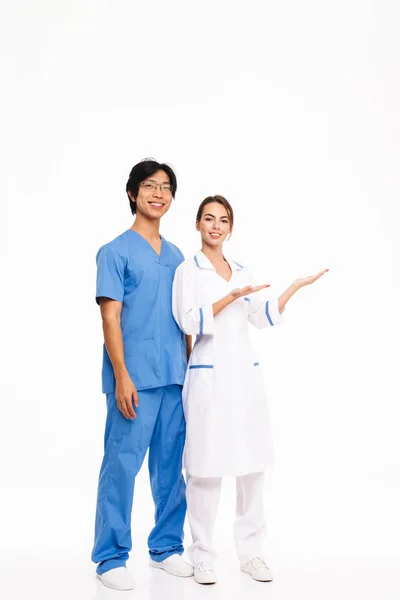 Usmívající Pár Lékařů Nosí Jednotné Postavení Izolované Nad Bílým Pozadím — Stock fotografie