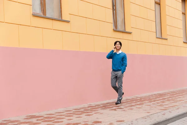 Sorrindo Jovem Asiático Homem Negócios Falando Telefone Celular Enquanto Caminhava — Fotografia de Stock