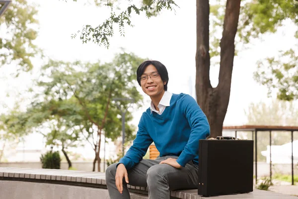 Sonriente Joven Asiático Hombre Negocios Sentado Aire Libre Con Maletín — Foto de Stock