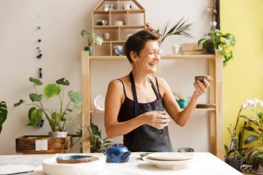 Kadın çömlekçi atölyesinde çay içme