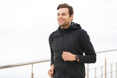 Beyaz sporcu 30s boyunca deniz iskelede çalışan siyah spor giyim görüntü