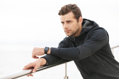 Olgun sportif Erkek 30'lu siyah spor giyim ayakta İskelesi sahil'üzerinde görüntü