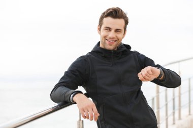 Sportif adam 30'lu siyah spor giyim ayakta İskelesi sahil'gülümseyen bir görüntü