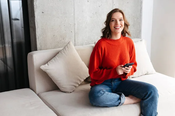 Cheerful Young Casually Dressed Woman Sitting Couch Home Holding Mobile — Stock Photo, Image