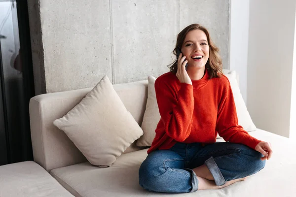 Joven Alegre Casualmente Vestida Mujer Sentada Sofá Casa Hablando Por — Foto de Stock