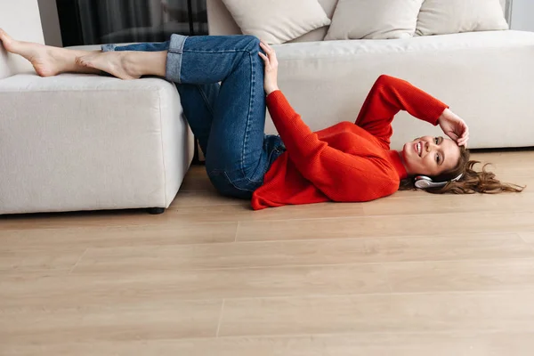 Cheerful Young Casually Dressed Woman Laying Floor Home Listening Music — Stock Photo, Image