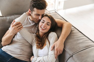 Evde bir kanepede döşenmesi, kucaklayan mutlu genç çift