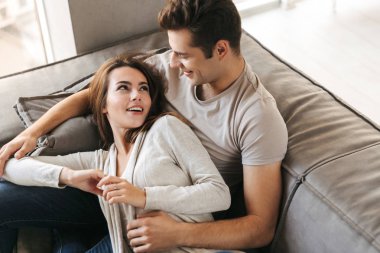 Evde bir kanepede döşenmesi, kucaklayan mutlu genç çift