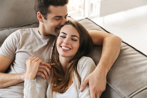 Feliz Joven Pareja Acostada Sofá Casa Abrazando — Foto de Stock