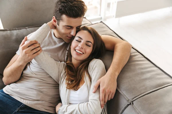Happy Young Couple Laying Couch Home Embracing — Stock Photo, Image