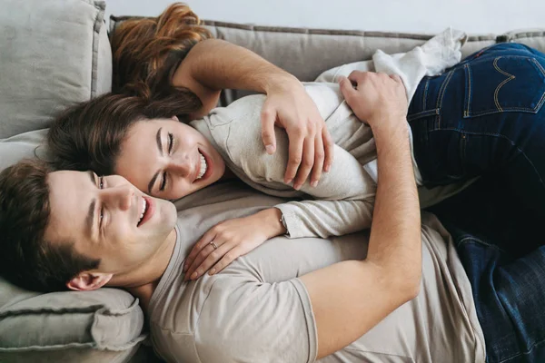 Jovem Casal Feliz Relaxando Sofá Casa Abraçando — Fotografia de Stock