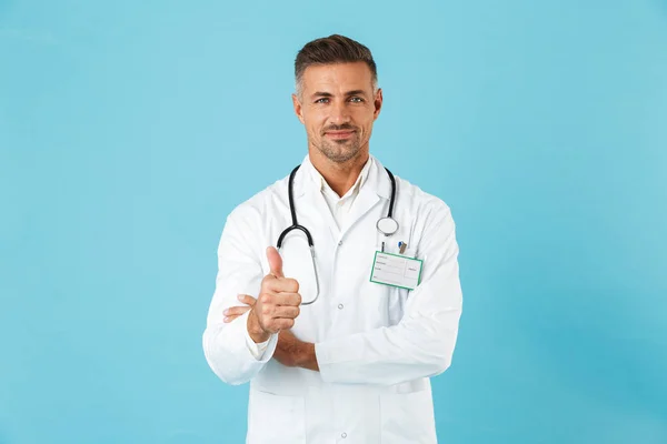 Homem Confiante Médico Vestindo Unifrom Isolado Sobre Fundo Azul Dando — Fotografia de Stock