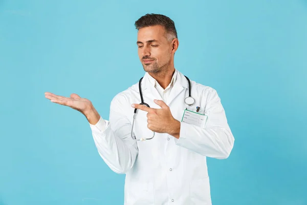 成人医生的肖像与听诊器站立站立在蓝色背景 — 图库照片