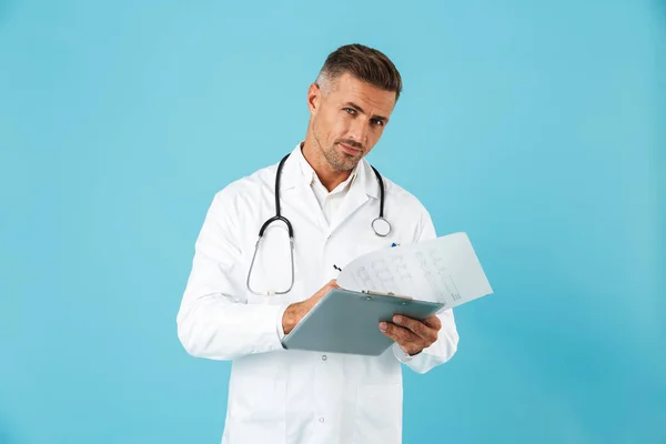 欧洲医生的肖像与听诊器举行健康卡站立在蓝色背景隔离 — 图库照片