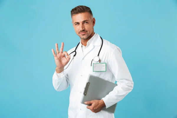 专业医生手持健康卡的肖像 站在蓝色背景上 — 图库照片