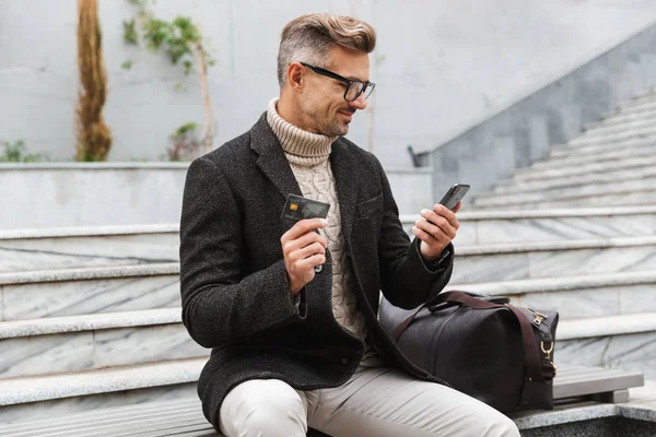 Красивий Чоловік Куртці Покупки Онлайн Мобільним Телефоном Кредитною Карткою Сидячи — стокове фото