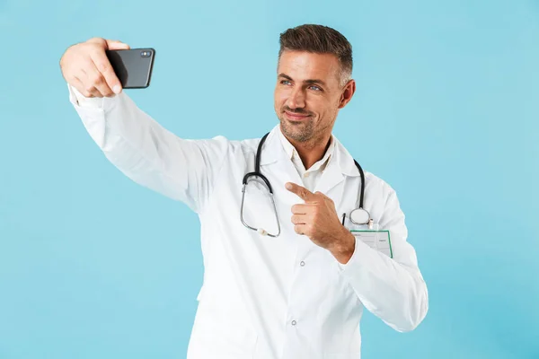 Foto Médico Alegre Vestindo Casaco Branco Estetoscópio Tomando Selfie Telefone — Fotografia de Stock