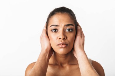 Adamın elleri beyaz arka plan üzerinde izole kulaklarını kapsayan süre oturan genç Afrikalı kadın korkuttu