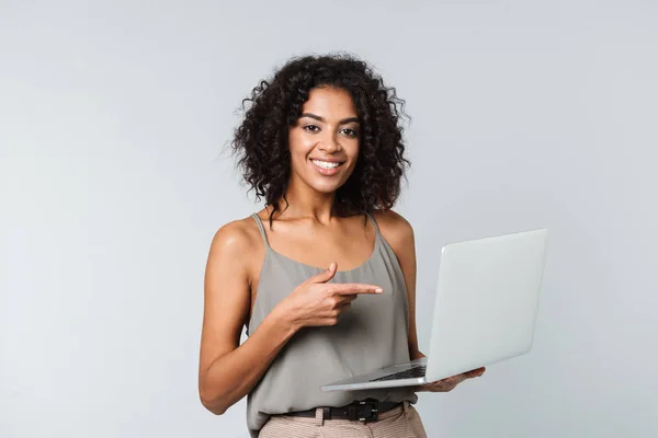 全长一个快乐的年轻非洲妇女随意打扮站在灰色背景孤立 在笔记本电脑上工作 — 图库照片