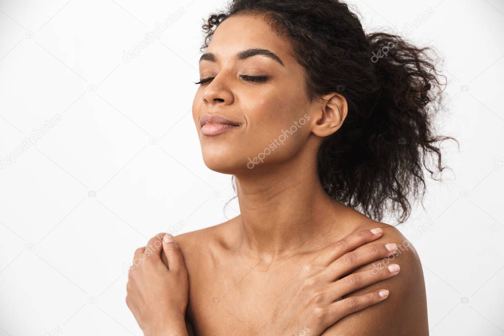 Close up of a beautiful young topless african woman posing over white background