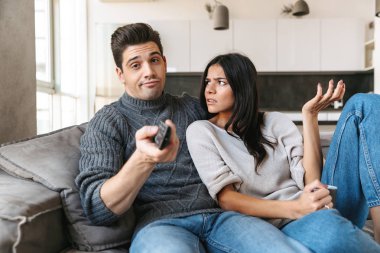 Evde bir kanepede oturan, Tv izlerken, çay içme sıkılmış genç çift