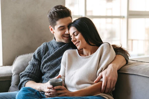 Pareja Joven Feliz Sentada Sofá Casa Viendo Televisión Tomando — Foto de Stock