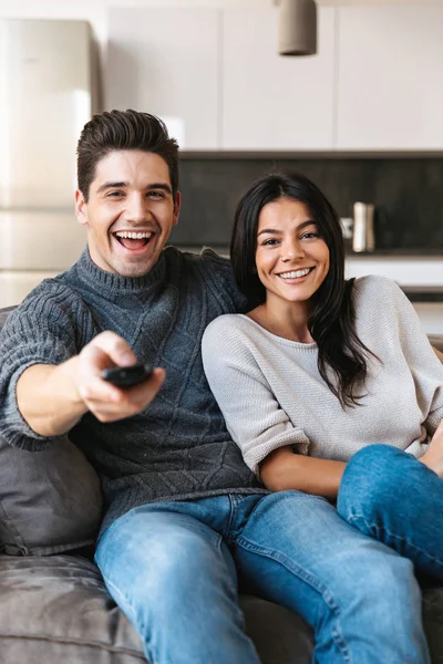 Pareja Joven Feliz Sentada Sofá Casa Viendo Televisión Tomando — Foto de Stock