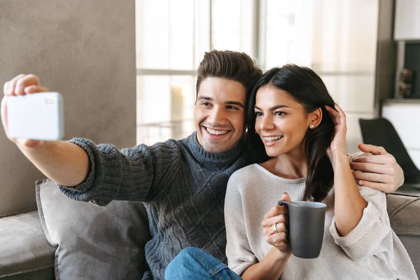 Happy Young Couple Sitting Couch Home Drinking Tea Taking Selfie — Stock Photo, Image