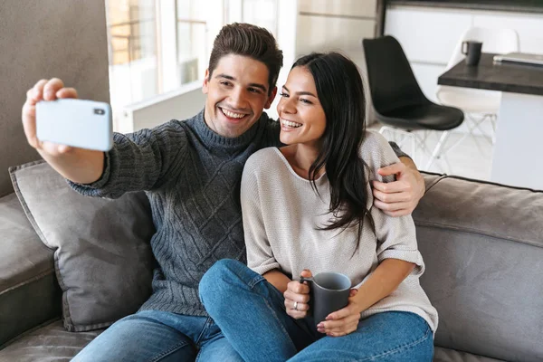 Happy Young Couple Sitting Couch Home Drinking Tea Taking Selfie — Stock Photo, Image