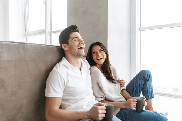 Feliz Pareja Joven Encantadora Sosteniendo Copas Mientras Sienta Suelo Sofá —  Fotos de Stock