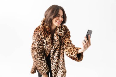 Bir selfie alarak leopar kürk manto üzerinde beyaz, izole ayakta giyen güzel kadın