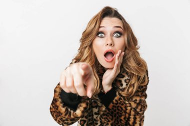 Kameraya gösteren beyaz arka plan üzerinde izole ayakta leopar ceket giyen güzel genç kadın