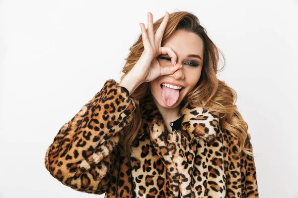 Tamam gösterilen beyaz arka plan üzerinde izole ayakta leopar ceket giyen güzel genç kadın