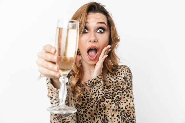 シャンパンのグラスを見せて立って白い背景に 孤立したヒョウのブラウスを着て美しい若い女性 — ストック写真