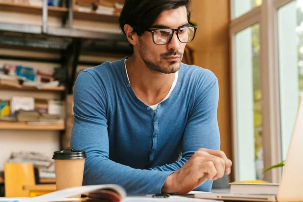 Beau Jeune Homme Confiant Portant Des Lunettes Assis Bureau Bibliothèque — Photo