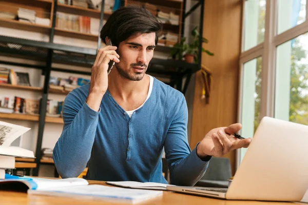 Joven Guapo Confiado Sentado Escritorio Biblioteca Trabajando Estudiando Usando Ordenador — Foto de Stock