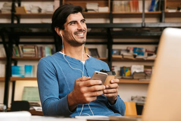 Guapo Joven Confiado Usando Auriculares Sentados Escritorio Biblioteca Trabajando Estudiando — Foto de Stock