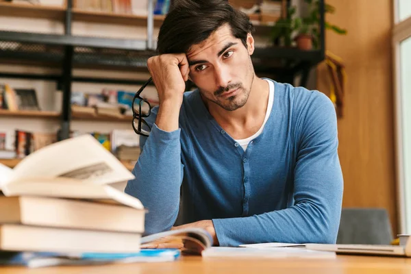 Bonito Jovem Cansado Sentado Mesa Biblioteca Trabalhando Estudando — Fotografia de Stock