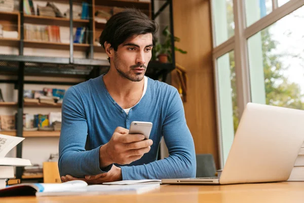 Joven Guapo Confiado Sentado Escritorio Biblioteca Trabajando Estudiando Usando Ordenador — Foto de Stock