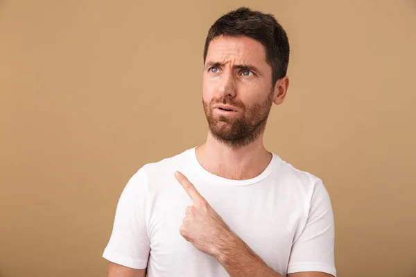 Portrait Surprised Young Man Casually Dressed Standing Isolated Beige Pointing — Stock Photo, Image